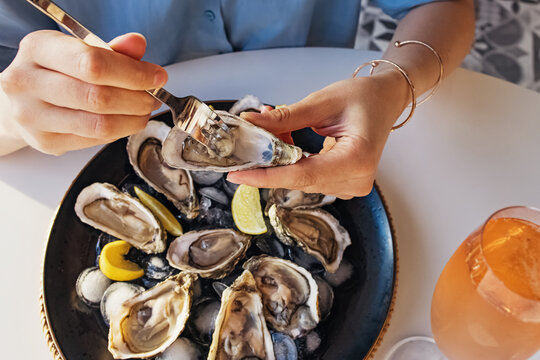 Woman Eating Fresh Oysters With Lemon Close-up.