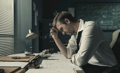 Math student sitting at desk and reviewing his papers