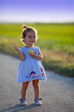 Ni&ntilde;a contenta con pirri en el campo al atardecer