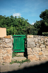 old green wooden gate with stone fence.
