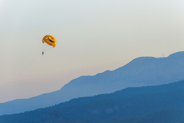 Smiling Parashute, Parasailing against the background of the mountain ridge  near Kemer, in Turkey.