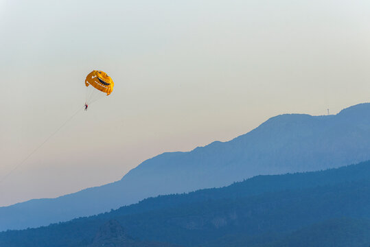 Smiling Parashute, Parasailing against the background of the mountain ridge  near Kemer, in Turkey.
