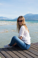 Fototapeta na wymiar girl with blond hair in glasses resting on Lake Garda in Italy