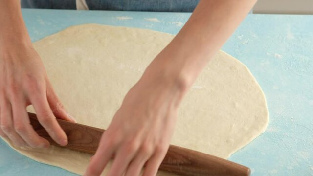 Young woman knead the dough with hands flour bake pastry at home, housewife lady cooking in the modern kitchen alone preparing cake pie.