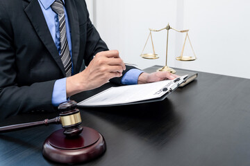 Professional male lawyers work at a law office There are scales, Scales of justice, judges gavel, and litigation documents. Concepts of law and justice