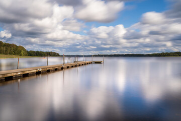Long exposure over jetty and lake with clouds and reflection. Location is Vastersjon, Sweden.