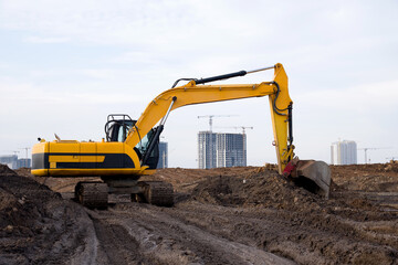 Excavator during excavation at construction site. Backhoe on road work. Heavy Construction...
