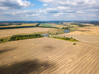 Fototapeta na wymiar Aerial drone view. Harvested wheat field on a sunny day.