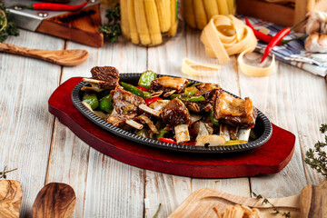 Roasted ribs meat with vegetables in cast iron pan