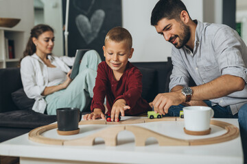 young family enjoying time with their son at home