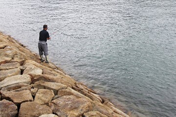 Fototapeta na wymiar Old Man Fishing at Beach