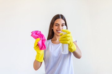 Young woman doing house chores holding cleaning tools. Woman wearing rubber protective yellow gloves, holding rag and spray bottle detergent. It's never too late to clean