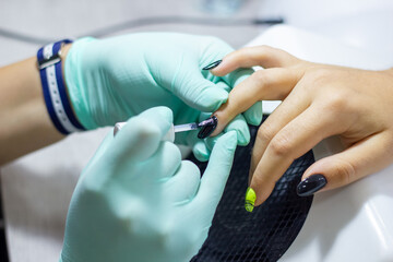 professional manicurist doing nail polish in beauty salon, professional manicurist at work