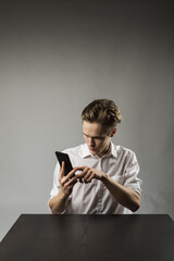 Young man in white using smartphone.