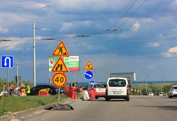 Road closed for repair: road warning signs against the blue sky