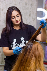 hairdresser at work, young hairdresser dyes the client's hair