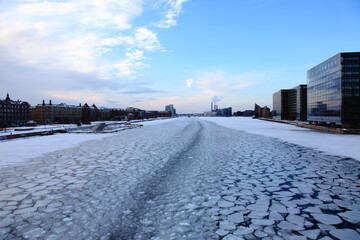 Copenhagen frozen river and city in winter with snow.