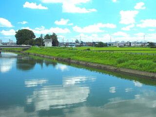 Naklejka premium 真夏の郊外の放水路風景