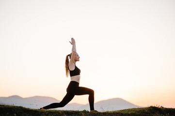 Fototapeta na wymiar Meditation. Woman balanced, practicing meditation and zen energy yoga in mountains. Girl doing fitness exercise sport outdoors in morning. Healthy lifestyle concept. Sunrise. Side view.