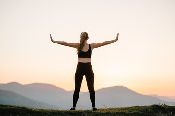 Fototapeta na wymiar Woman balanced, practicing meditation, zen energy yoga in mountains. Healthy lifestyle concept. Young girl doing fitness exercise sport outdoors. Morning sunrise. Relax in nature. Back view.