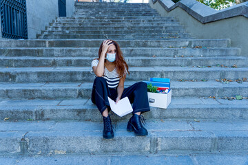 Sad woman sitting outside office feeling hopeless after being fired. Coronavirus job cuts crisis