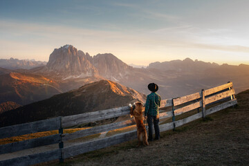 a man with a red dog looking at the mountains. Dolomites Alps. hiking, relax. Nova Scotia Duck...