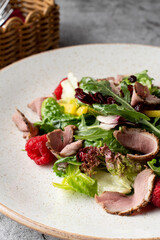 Light gourmet salad with meat slices, lettuce and raspberry, fine dining italian restaurant