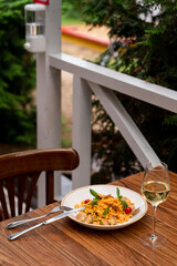 Summer dinner in Italy on a terrace with wine and pasta