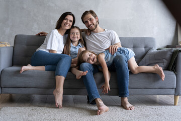 Cheerful family at home sitting in sofa