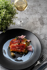 Top view of a chef's special in a restaurant: fried fish with couscous and blue sauce, grey stone table
