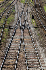 Fototapeta premium Railway top view background. Train transport industry. Vertical rail track texture. Good and cheap way of transportation for cargo. Old railroad wooden tie. Track ballast gravel made of crushed stone.