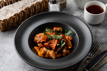 Traditional german veal ragout with big potato chunks on a grey background,?menu photography