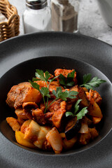 Vertical menu photo for a restaurant:  meat and potato ragout with tomato sauce
