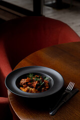 Atmospheric photo of a restaurant dinner in red and terracotta colors, deep shadows and dark plates
