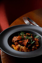 Close up of pork and potato stew in a dark posh restaurant