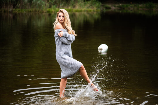 Sensual portrait of a blonde woman in a gray sweater oversize