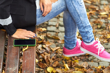 Fototapeta premium Young caucasian woman holding modern smartphone on the street.