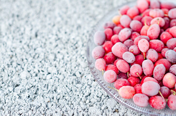 Frozen berries, covered with frost - dogwood on a gray concrete background. Space for text, copy space. Top view, flat lay