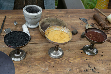 charcoal, sulfur, saltpeter in bowls for making black powder. Сasting of lead bullets according to the technology of the 17th century