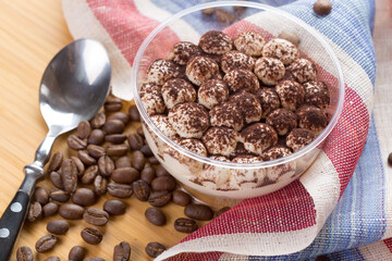 Tiramisu dessert in a glass cup on wooden table