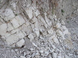 Natural background. Closeup edged shabby cliff cracks. Gray-brown stone rock texture of mountains. Vintage and faded matt style colour in tinted photo. Concept of geolog, mountaineering or hard work.