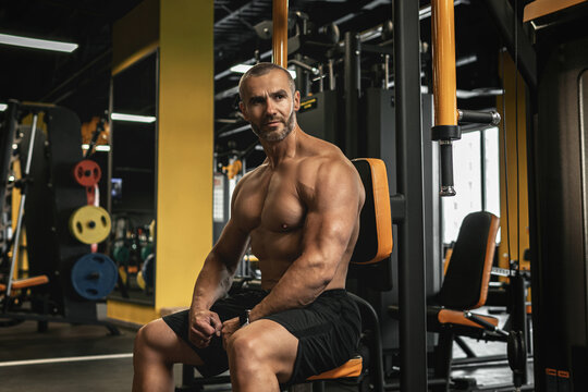 Handsome and muscular bodybuilder in a gym during workout