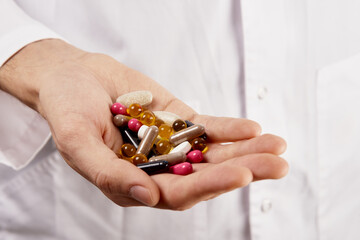 Dietary supplements in the palm of a male doctor close-up, pills and tablets