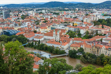 Fototapeta na wymiar オーストリア　グラーツのシュロスベルクの丘から見えるグラーツ市街歴史地区の街並みとムーアインゼル