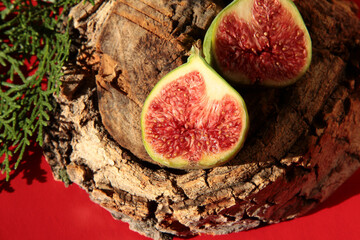 Two halves of a Fig on a tree stump.. Fruit on a wooden background.