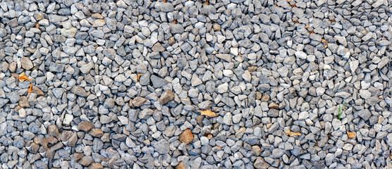 small road stone panorama background. dark gravel pebbles stone texture