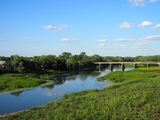 Beautiful summer landscape with a view of an old vintage bridge over a small river