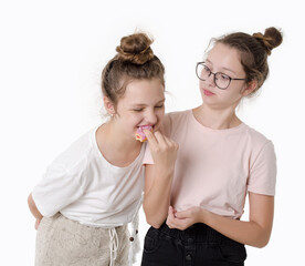 Two girls eat sweet donut and smile, Studio portrait on white background