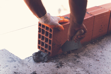 Bricklayer builder working. Walling, installing bricks on construction site, Engineering and...
