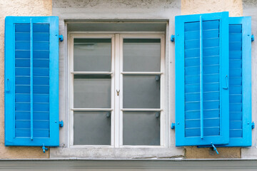 White old vintage window with blue shutters.